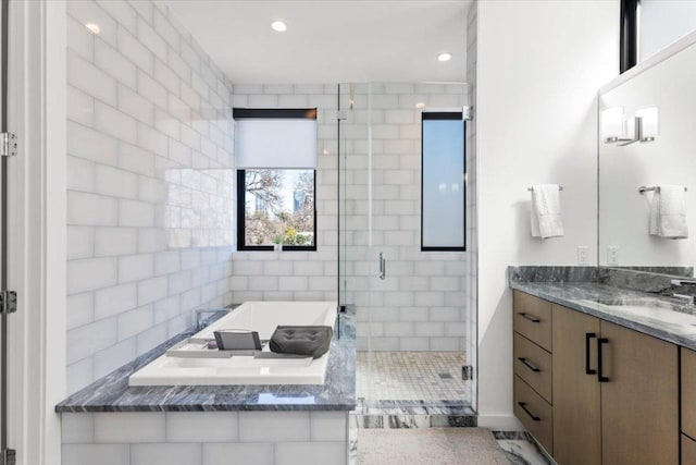 bathroom with recessed lighting, a garden tub, a shower stall, and vanity