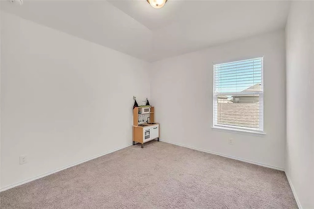 spare room with light colored carpet and baseboards