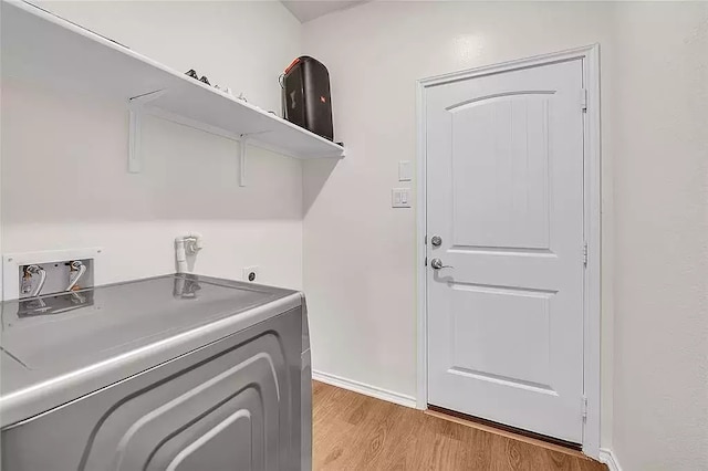 washroom featuring light wood-type flooring, laundry area, baseboards, and washer / clothes dryer