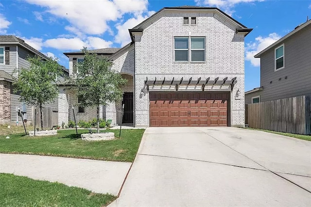 view of front of home with an attached garage, brick siding, fence, driveway, and a front lawn