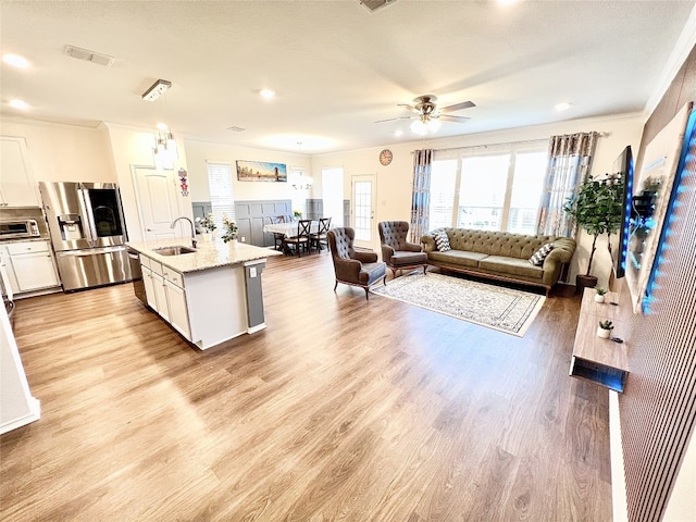 kitchen featuring appliances with stainless steel finishes, a toaster, a sink, and light wood finished floors