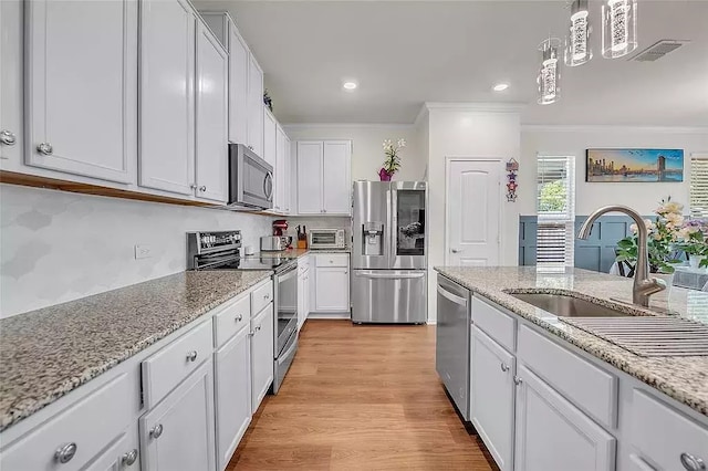 kitchen featuring a sink, visible vents, white cabinetry, ornamental molding, and appliances with stainless steel finishes