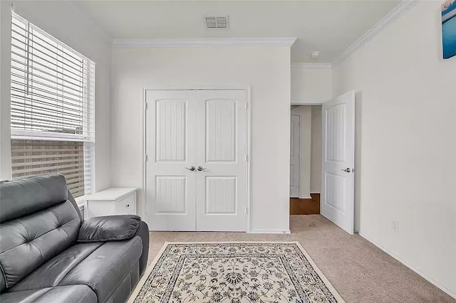 living area with light colored carpet, crown molding, visible vents, and baseboards