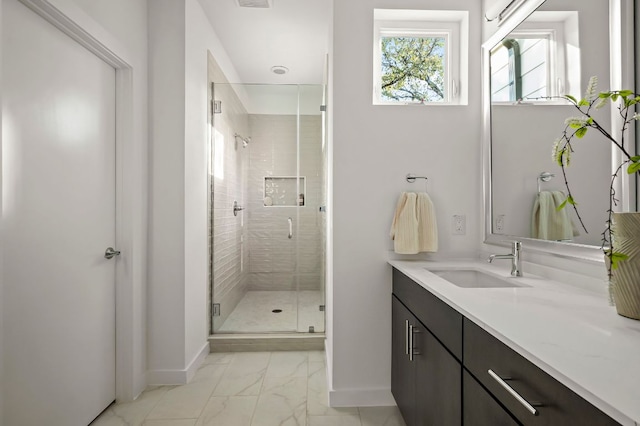 bathroom featuring marble finish floor, vanity, baseboards, and a stall shower