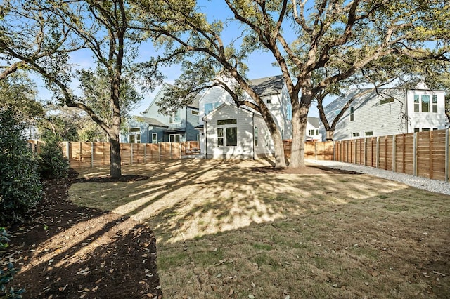 back of property featuring a lawn and a fenced backyard