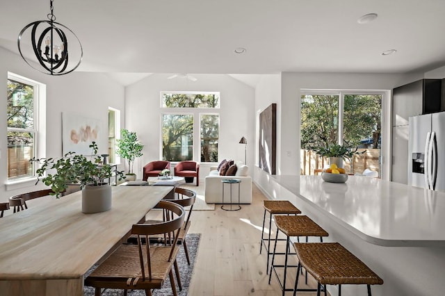 dining space with vaulted ceiling, plenty of natural light, and light wood-style floors