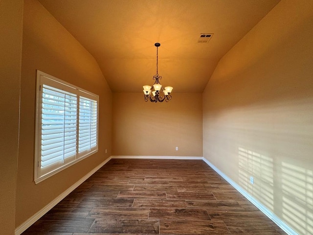 spare room featuring visible vents, dark wood-style floors, an inviting chandelier, baseboards, and vaulted ceiling