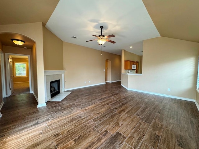 627 Columbine Ave, Cedar Park, TX 78613 - unfurnished living room with lofted ceiling, dark wood-style floors, a ceiling fan, baseboards, and arched walkways