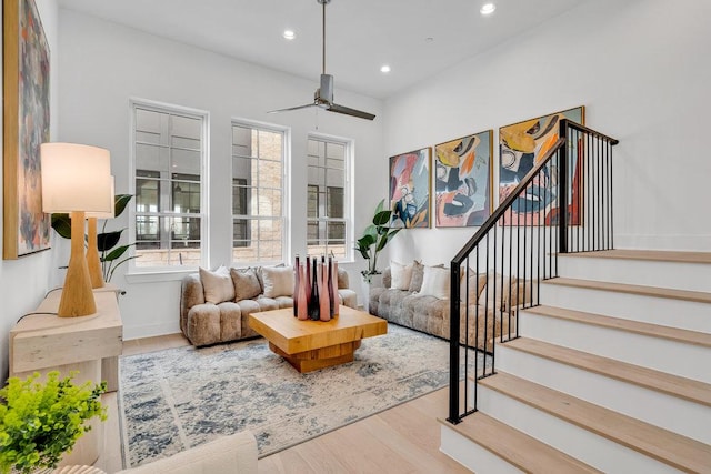 living area with ceiling fan, stairs, wood finished floors, and recessed lighting