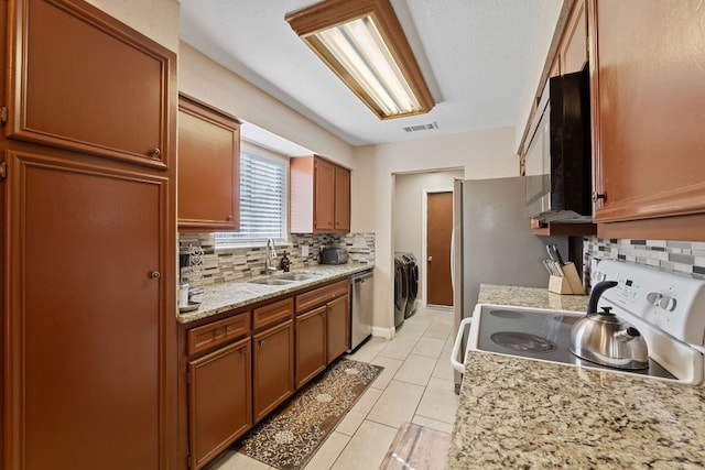 kitchen featuring light tile patterned floors, a sink, visible vents, appliances with stainless steel finishes, and decorative backsplash