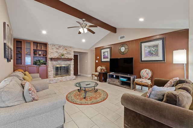 living room featuring vaulted ceiling with beams, light tile patterned floors, a stone fireplace, ceiling fan, and visible vents