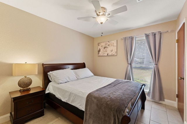 bedroom featuring light tile patterned floors, ceiling fan, multiple windows, and baseboards