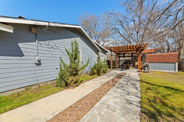 view of home's exterior featuring fence, a patio, an outdoor structure, and a pergola