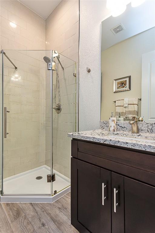 5608 Arroyo Rd, Austin, TX 78734 - bathroom with a stall shower, vanity, and wood finished floors