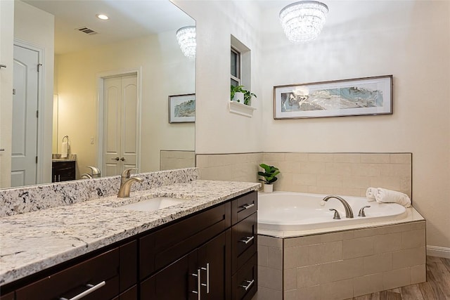 5608 Arroyo Rd, Austin, TX 78734 - full bath with vanity, a garden tub, wood finished floors, and a chandelier