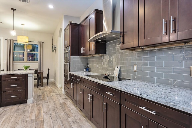 5608 Arroyo Rd, Austin, TX 78734 - kitchen with wall chimney range hood, black electric cooktop, light wood finished floors, and tasteful backsplash