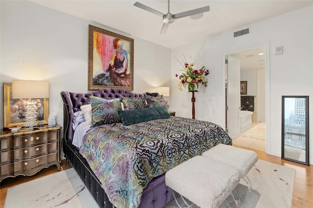 bedroom with a ceiling fan, visible vents, and wood finished floors