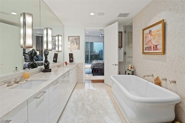 ensuite bathroom featuring double vanity, a soaking tub, visible vents, connected bathroom, and a sink