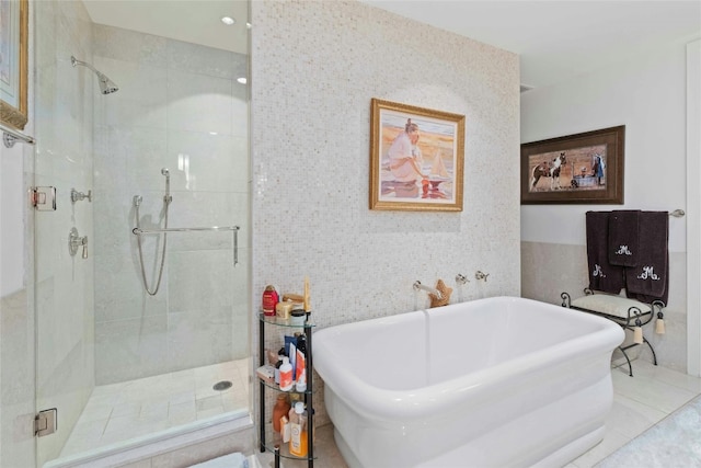 full bathroom with a stall shower and a freestanding bath