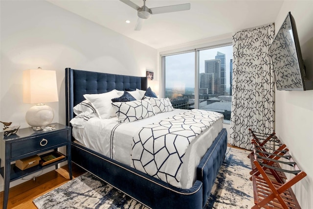 bedroom featuring access to outside, wood finished floors, and a ceiling fan