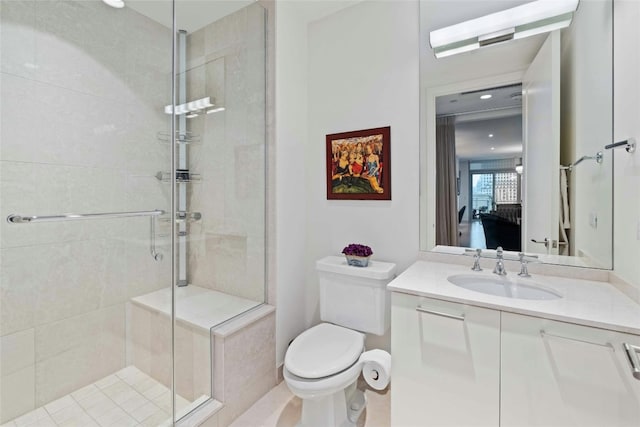 bathroom with toilet, a shower stall, and vanity