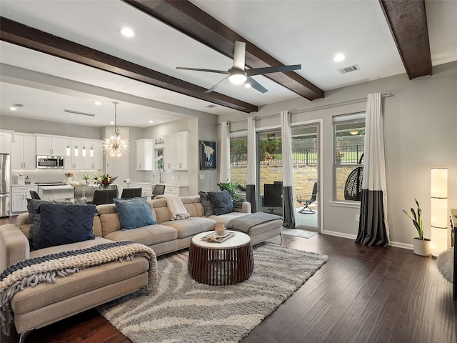 living room with ceiling fan with notable chandelier, dark wood-style flooring, visible vents, baseboards, and beamed ceiling