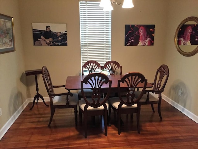 dining room with dark wood-style flooring, baseboards, and an inviting chandelier