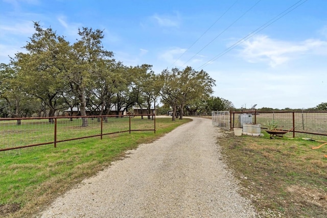 view of street with driveway and a rural view