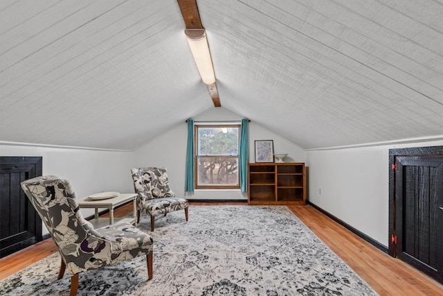 sitting room with light wood-style floors, lofted ceiling with beams, and baseboards