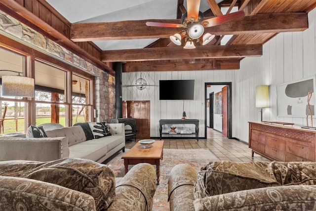 tiled living room with lofted ceiling with beams, a wood stove, and a ceiling fan