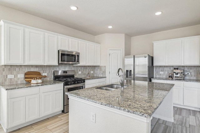 20417 Whimbrel Ct, Pflugerville, TX 78660 - kitchen featuring stainless steel appliances, a sink, decorative backsplash, an island with sink, and recessed lighting