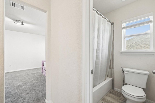 full bath featuring shower / bath combination with curtain, visible vents, toilet, and baseboards