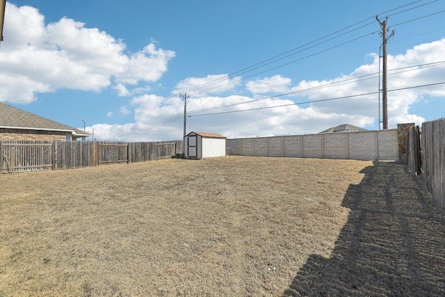 view of yard with a shed, an outdoor structure, and a fenced backyard