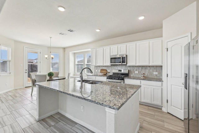 20417 Whimbrel Ct, Pflugerville, TX 78660 - kitchen featuring appliances with stainless steel finishes, a sink, tasteful backsplash, white cabinets, and light stone countertops