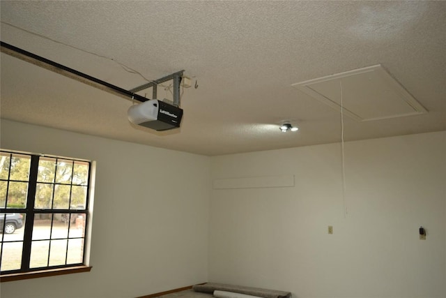 interior space with a textured ceiling and attic access