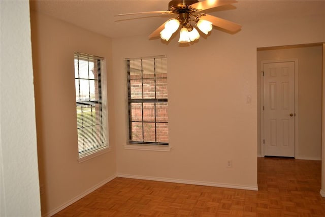 unfurnished room with ceiling fan and baseboards