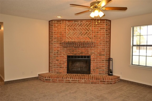 unfurnished living room with carpet floors, a wealth of natural light, and a fireplace