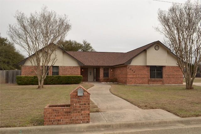 ranch-style house featuring brick siding, a front lawn, and fence