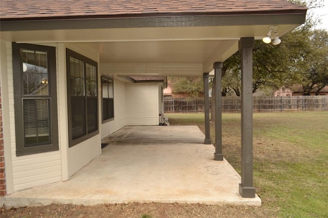 view of patio featuring a carport and fence