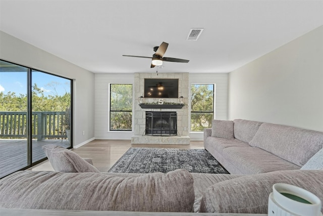 living room with a healthy amount of sunlight, a fireplace, visible vents, and wood finished floors