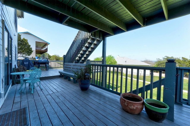 deck with stairs, a lawn, and area for grilling