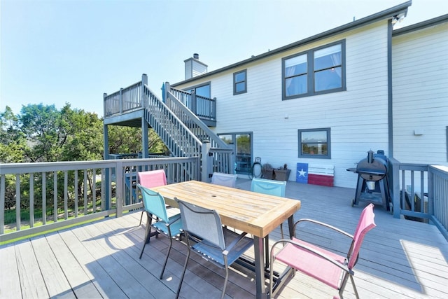 deck with outdoor dining space and stairway