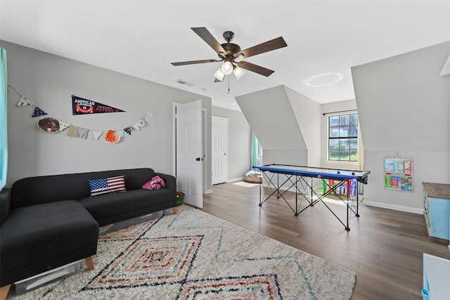 recreation room featuring baseboards, visible vents, ceiling fan, wood finished floors, and vaulted ceiling