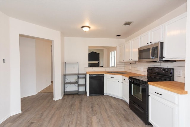 121 Winecup Path, Cedar Creek, TX 78612 - kitchen with black appliances, light wood-style flooring, and white cabinets