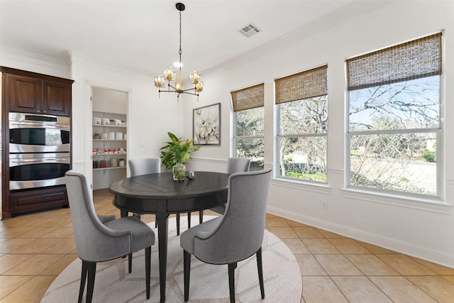 dining space with light tile patterned floors, baseboards, visible vents, crown molding, and a chandelier