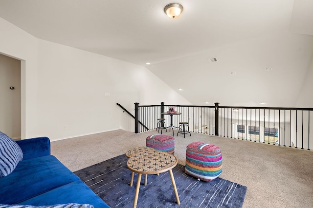 sitting room with lofted ceiling, carpet flooring, and an upstairs landing