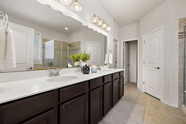 bathroom featuring tile patterned flooring, a sink, a shower stall, and double vanity