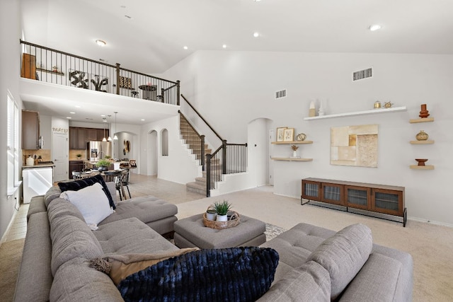 living area with arched walkways, stairs, and visible vents