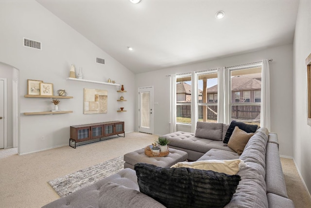 carpeted living room featuring high vaulted ceiling, arched walkways, visible vents, and recessed lighting