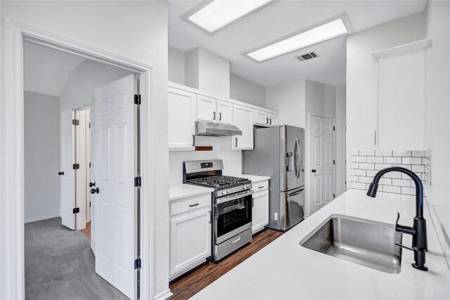 17616 Strontian Pass, Pflugerville, TX 78660 - kitchen featuring appliances with stainless steel finishes, under cabinet range hood, a sink, white cabinets, and tasteful backsplash